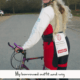 A person posing with a bike and wig in a parking lot