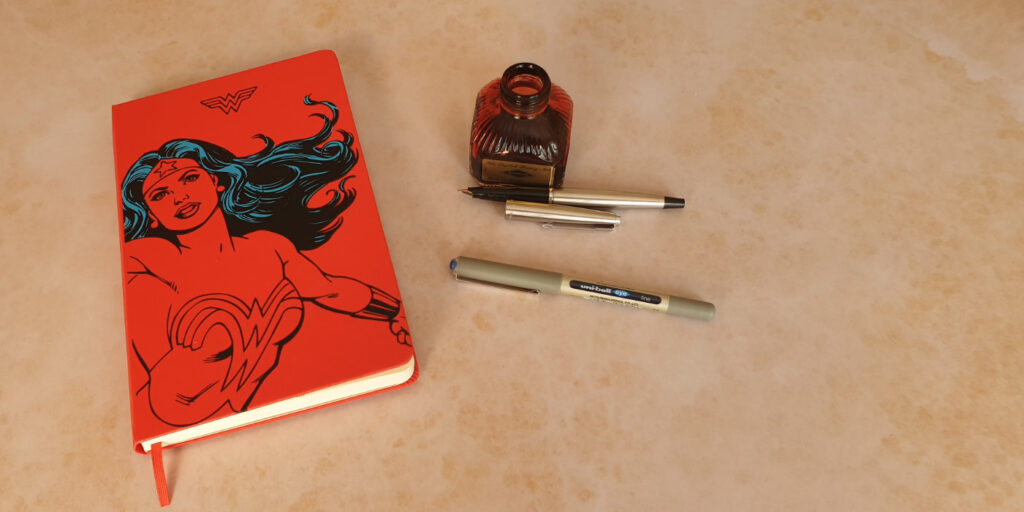 My second journal of 2020. A red Wonder Women Moleskine, shown here with a bottle of red Diamine ink and some pens