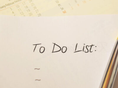 a calendar, pen and a piece of paper with handwriting that says To Do List