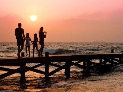 family stood on a pier at sunset