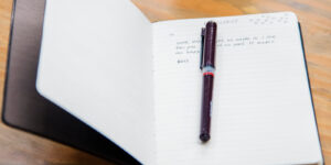 notebook open with a pen on its first page